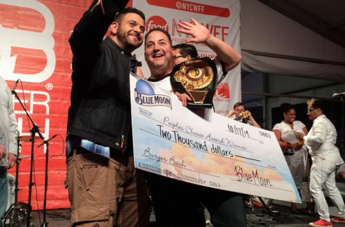 Adam Richman, Josh Capon holding a sign.