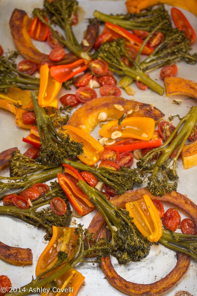 Sheet pan with roasted squash, broccolini, peppers, and tomatoes.