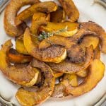 Plate of maple-balsamic roasted carnival squash with fresh thyme.