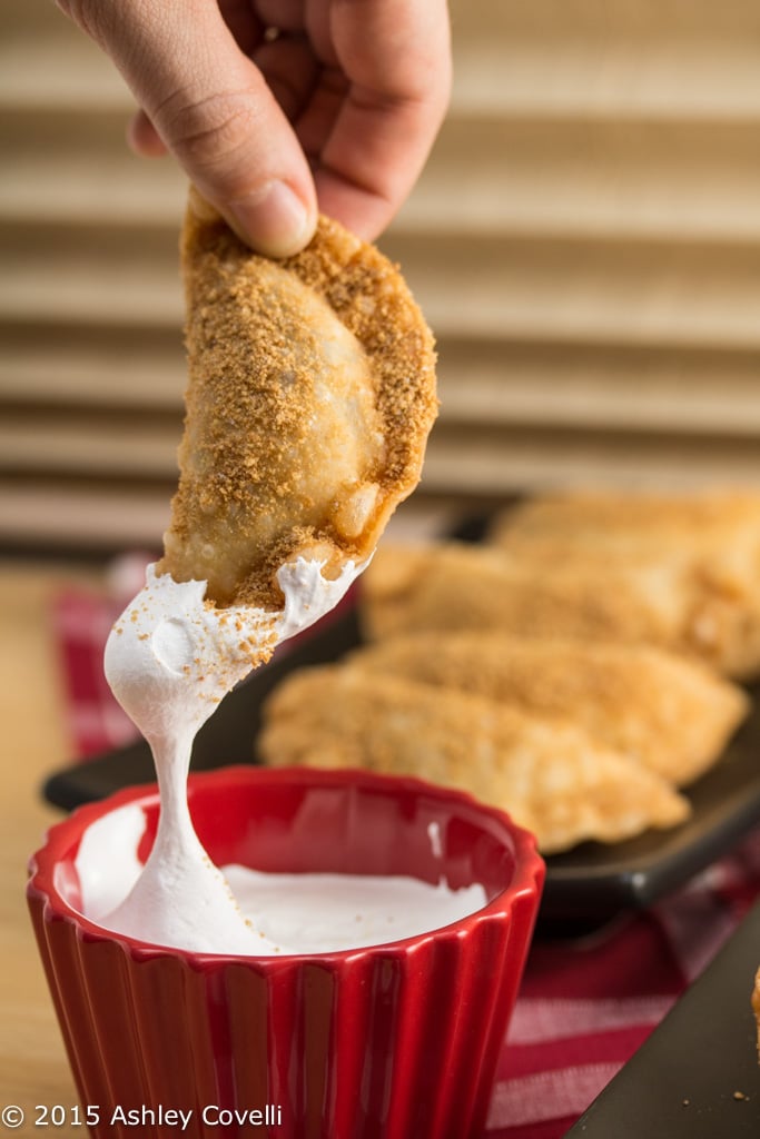 Dunking a Deep Fried Nutella S’mores Dumpling into marshmallow fluff.