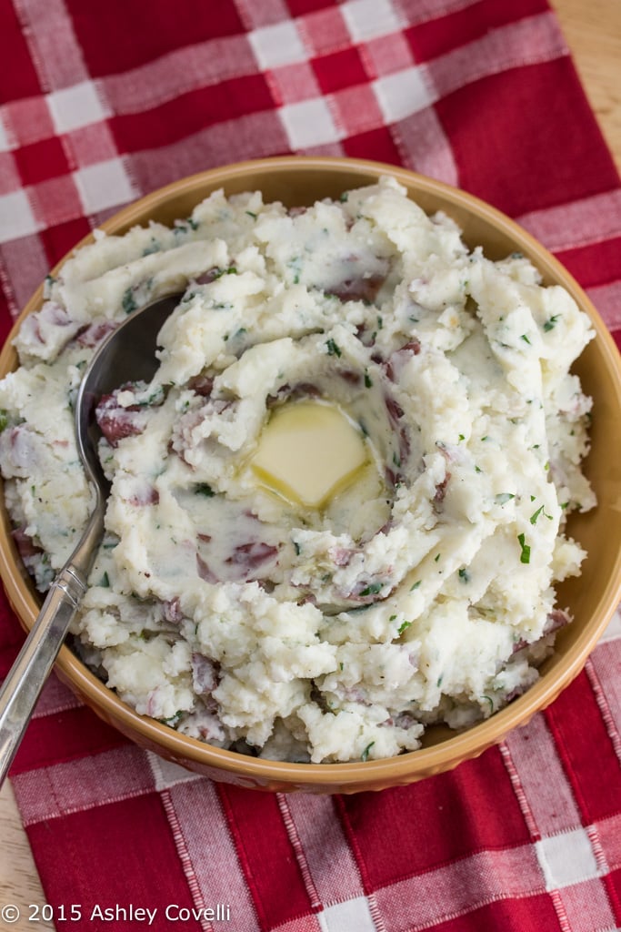 Bowl of garlic mashed potatoes with butter on top.