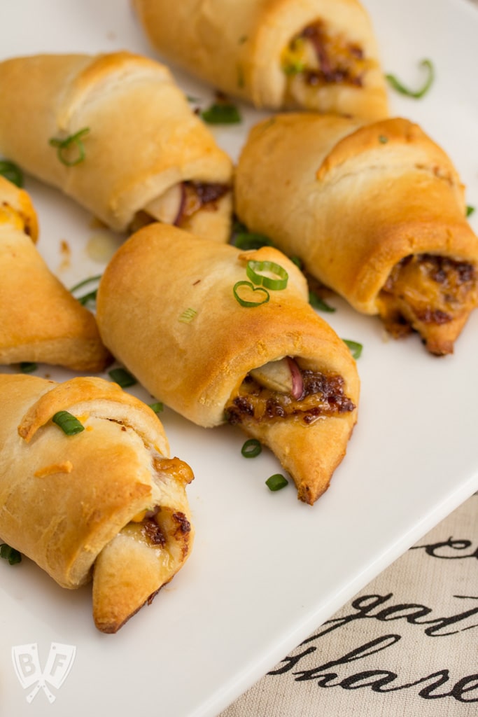 Croissants on a platter filled with apple, cheddar, and bacon jam.