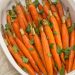 Carrots in a serving dish topped with parsley.