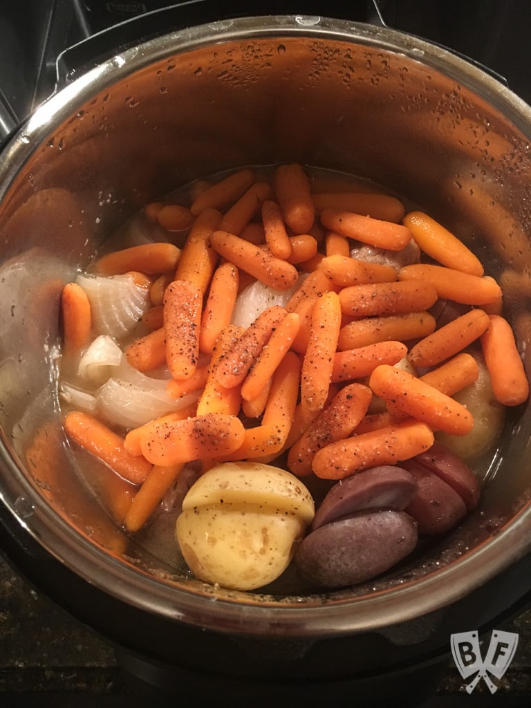 Overhead view of Instant Pot filled with carrots, potatoes, and onions.