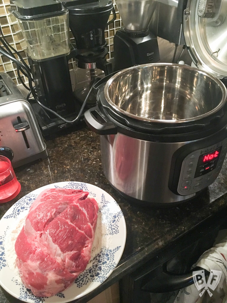 Pot roast on a platter getting ready to go into an Instant Pot.