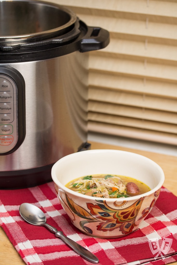 Bowl of soup with a spoon in front of an Instant Pot.