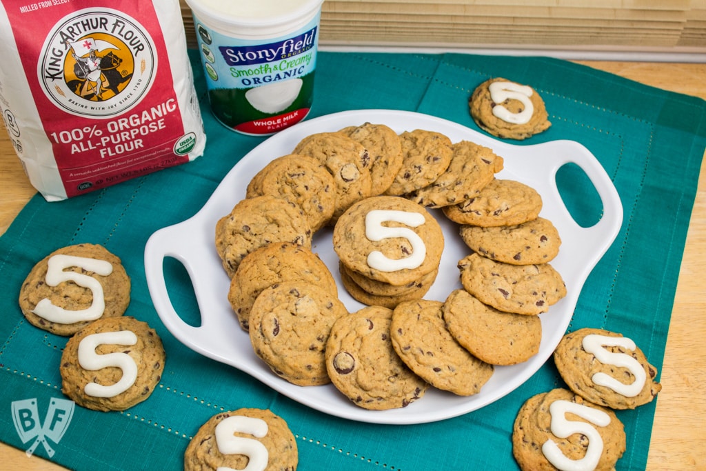 Platter of chocolate chip cookies with the number 5 written with icing.