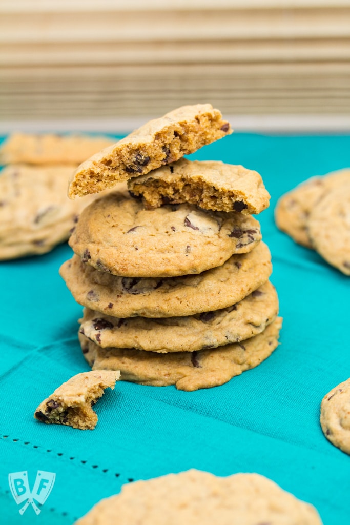 Stack of chocolate chip cookies with bites taken out of one.