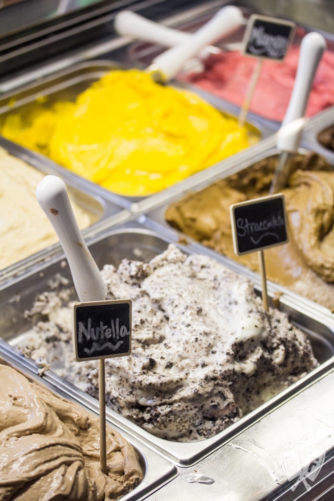 Bins of gelato with flavor labels.