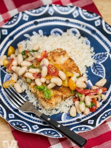 Pork Scallopini with White Bean-Tomato Salad: Need a quick weeknight dinner? Thin cut pork is coated in panko and fried till crispy, then topped with a vibrant salad that comes together in just minutes! A perfect use for canned white beans!