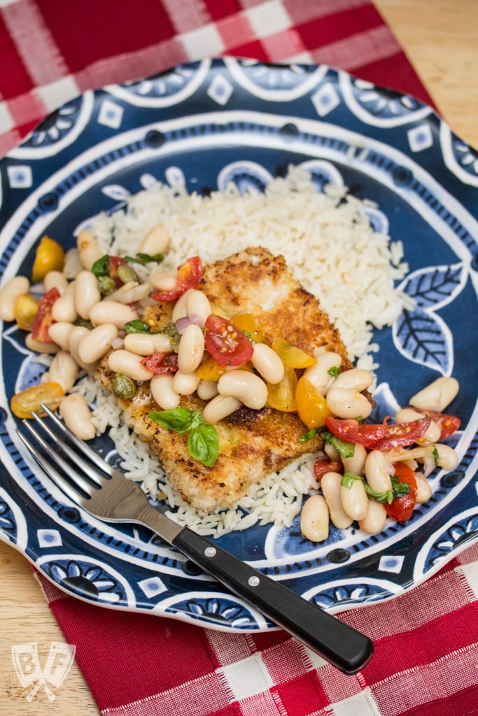 Pork Scallopini with White Bean-Tomato Salad: Need a quick weeknight dinner? Thin cut pork is coated in panko and fried till crispy, then topped with a vibrant salad that comes together in under 20 minutes! A perfect use for canned white beans!