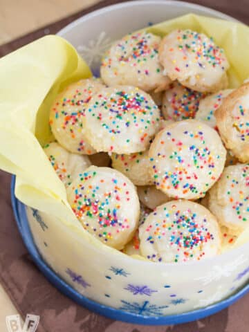 Container of ricotta cookies with tissue paper.