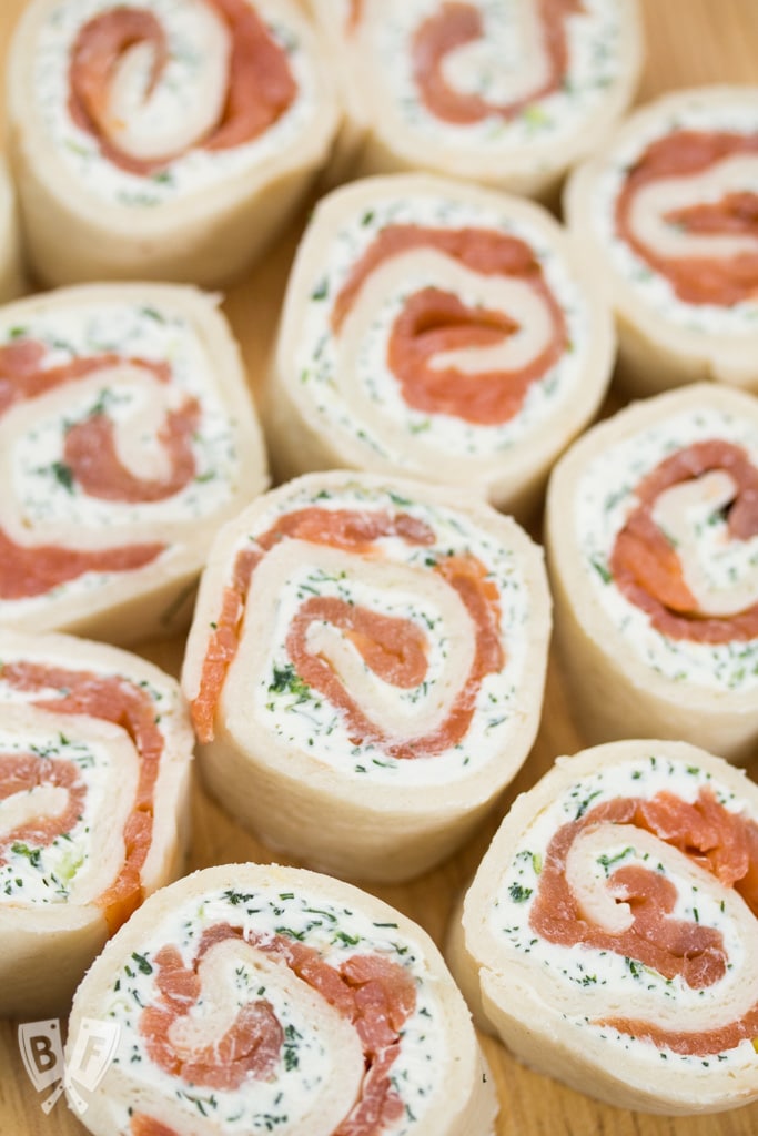 Overhead view of smoked salmon rolled in tortillas with dill cream cheese.