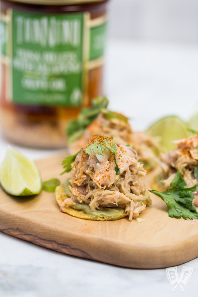 Mini tostadas topped with avocado, tuna, cilantro, and lime.