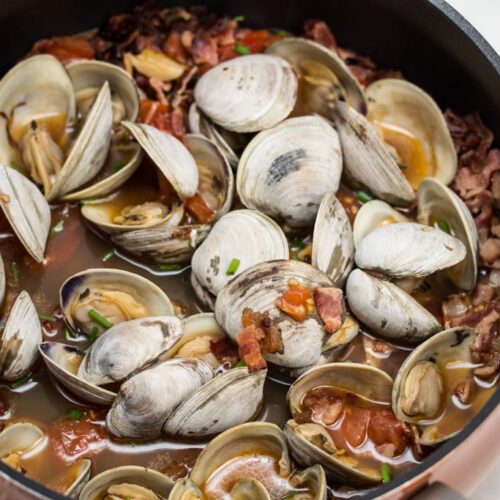 Garlicky Littleneck Clams with Bacon + Wine Over Sautéed Spring Veggies: A bed of sautéed veggies makes the perfect base for this bacon-loaded seafood dish. Make sure you have plenty of crusty bread for dunking! #BaconMonth