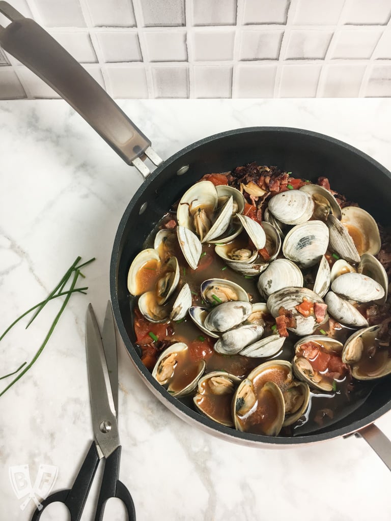 Garlicky Littleneck Clams with Bacon + Wine Over Sautéed Spring Veggies: A bed of sautéed veggies makes the perfect base for this bacon-loaded seafood dish. Make sure you have plenty of crusty bread for dunking! #BaconMonth