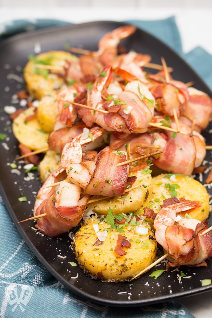 Big Shrimpin' Bacon-Wrapped Shrimp and Grit Cakes: Classic shrimp and grits gets an upscale makeover in this over-the-top, bacon-wrapped presentation. Easy, delicious, and sure to impress your dinner guests! #BaconMonth