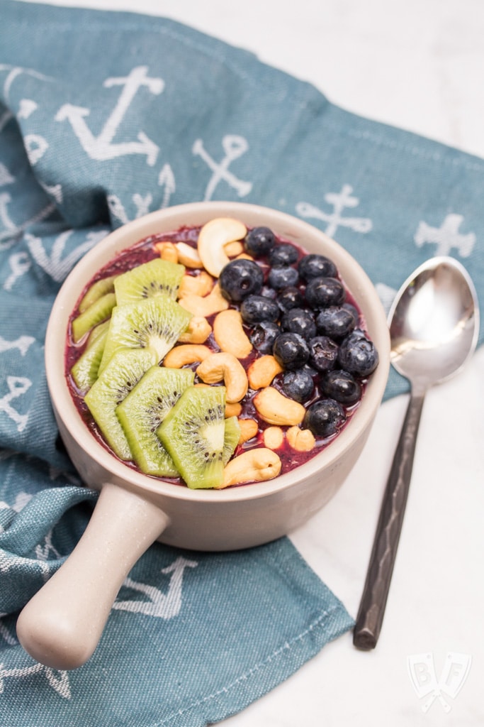 Smoothie bowl topped with fresh fruit and cashews.