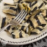 Overhead view of a plate of black and white striped sweet potato ravioli - a tribute to Beetlejuice