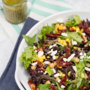 (#ad) Roma Salad with Caper-Dill Vinaigrette: Chickpeas, corn, black beans, feta cheese, + sun-dried tomatoes turn salad greens into a deliciously filling meal. Top it with a tangy homemade vinaigrette! #CookingWithCoke #CollectiveBias