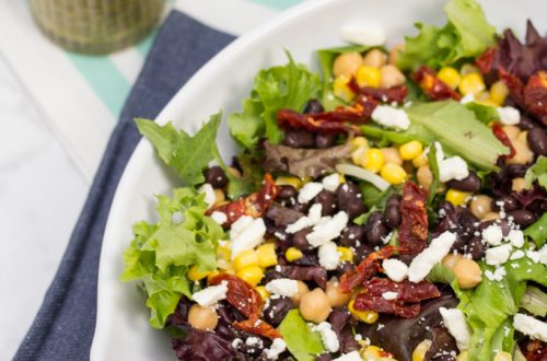 (#ad) Roma Salad with Caper-Dill Vinaigrette: Chickpeas, corn, black beans, feta cheese, + sun-dried tomatoes turn salad greens into a deliciously filling meal. Top it with a tangy homemade vinaigrette! #CookingWithCoke #CollectiveBias