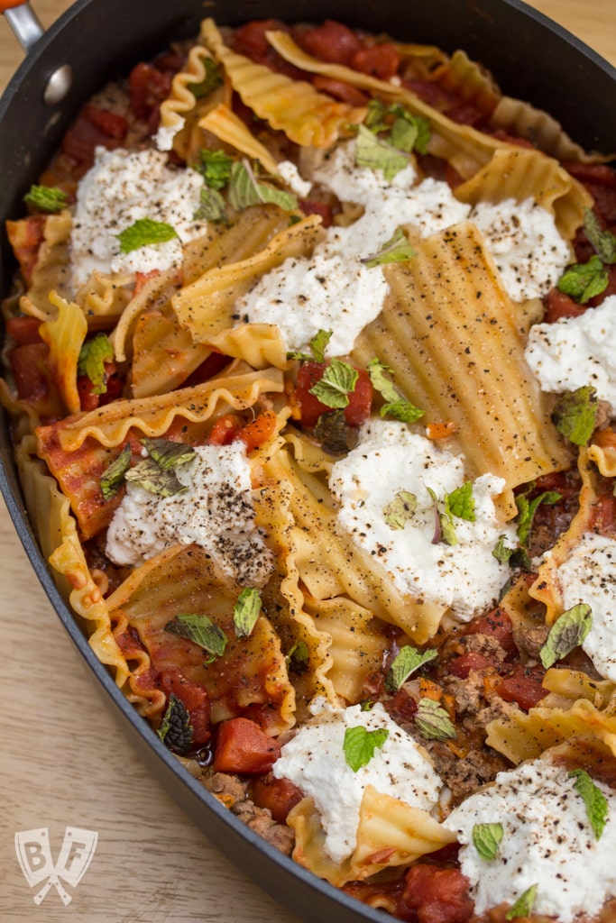 Overhead view of a skillet lasagna with lamb, ricotta, and mint.