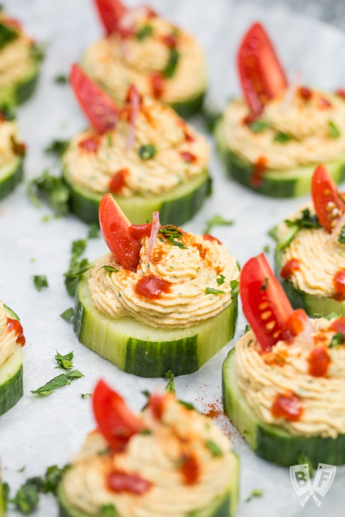 Close up of a few cucumber slices topped with a spiced chickpea purée.