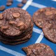 Chocolate cookies and chocolate chips on a blue and white backdrop.