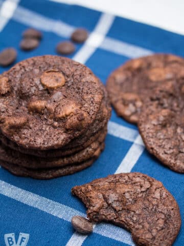 Chocolate cookies and chocolate chips on a blue and white backdrop.