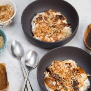 Overhead view of bowls of yogurt topped with coconut, caramel, and chocolate.