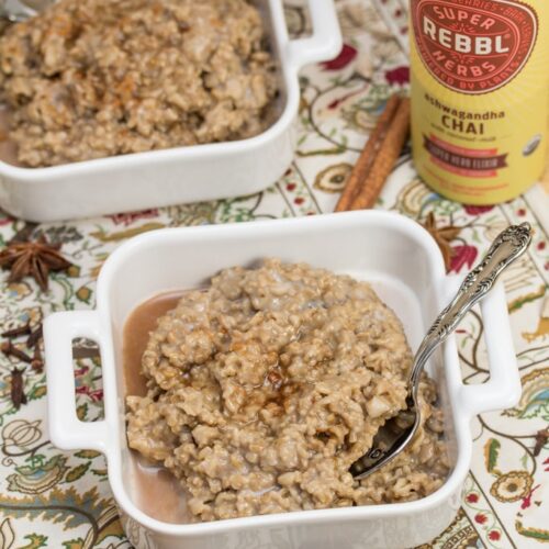 Bowls of ashwagandha chai porridge with spoons and whole spices alongside.