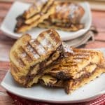Nutella and banana stuffed panini cut in half and dusted with powdered sugar.
