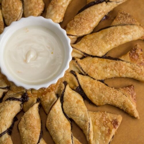 Overhead view of a dark chocolate pinwheel pastry with creamsicle yogurt dip in the middle.