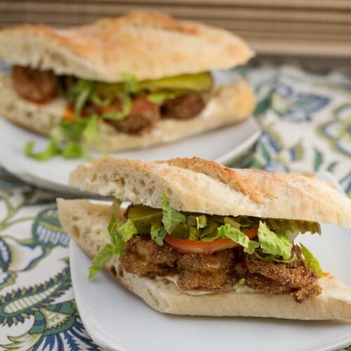 Emeril's Classic Fried Shrimp Po'boys on 2 plates.