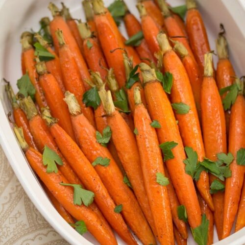 Overhead view of carrots in a dish sprinkled with parsley.