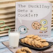 Milk and cookies next to a children's story book about cookies.