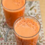 Two glasses of fresh carrot apple ginger juice.