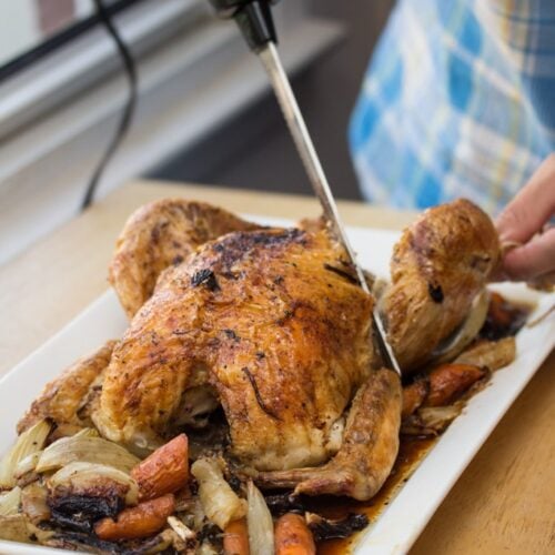 Carving a roasted chicken with an electric knife.
