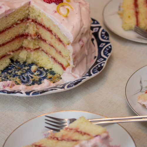 Strawberry lemonade layer cake with slices served on plates.
