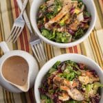 Two bowls of chopped salad with a pitcher of BBQ ranch dressing alongside.