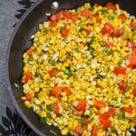 Fresh Corn Sauté with Red Pepper and Onions in a skillet.