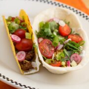 Soft shell and hard shell tacos on a plate.