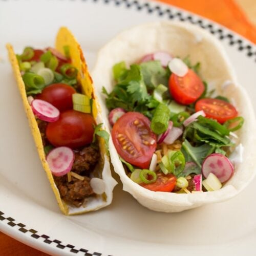 Soft shell and hard shell tacos on a plate.