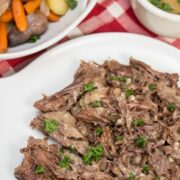 Platters of Instant Pot herbed pot roast, veggies, and gravy.