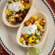 Plate of tofu and black bean taco boats topped with tropical salsa.