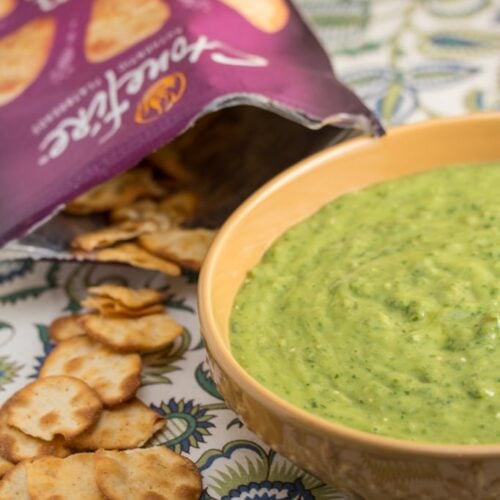 A bowl of chimi-verde dip with mini naan chips alongside.