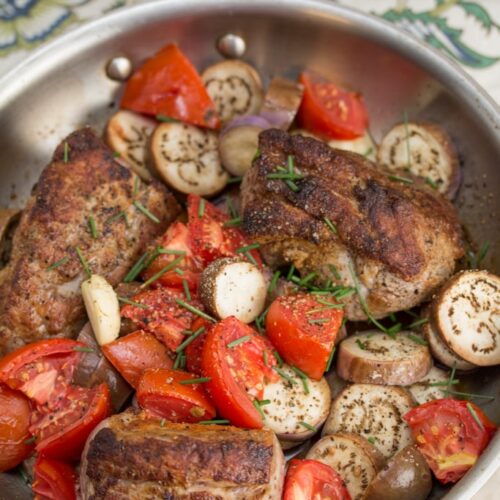 Skillet holding Pan Roasted Pork Tenderloin with Fairy Tale Eggplant & Tomatoes.