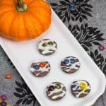 Frozen peanut butter cups on a platter, decorated like mummies for Halloween.