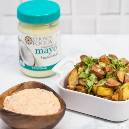 Patatas bravas in a bowl with chipotle mayo alongside.