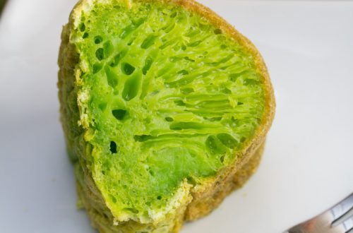 A slice of vibrant green Vietnamese honeycomb cake on a plate.